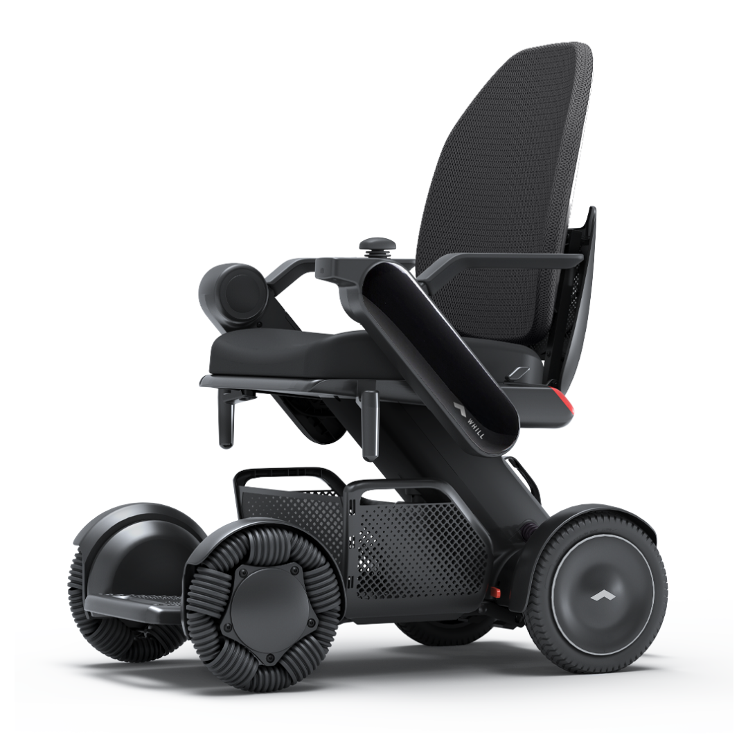 The Whill Model C2 High Back Smart Power Chair features a sleek black finish, mesh high backrest, padded armrests, and large omnidirectional wheels for smooth indoor and outdoor mobility. App-enabled RC control adds smart convenience.
